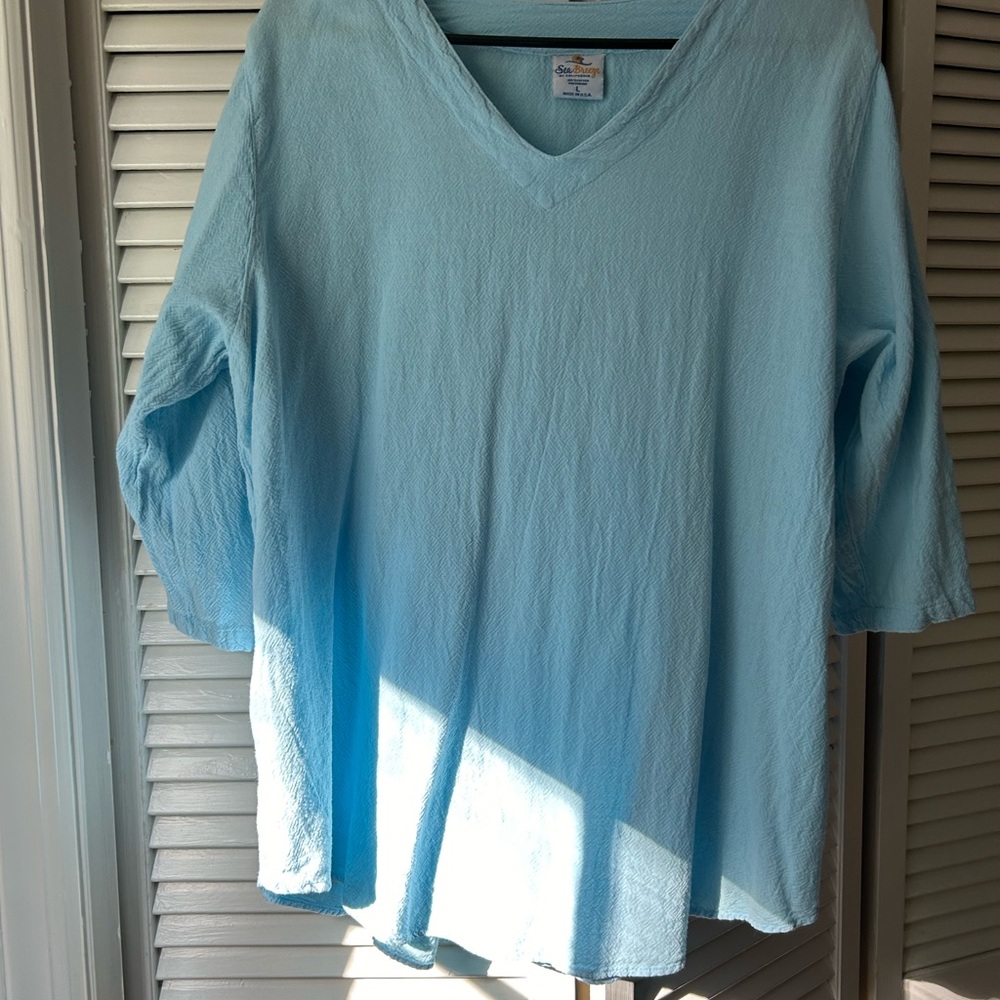 Baby blue top, 3/4 sleeves with breezy cut outs running down sleeve